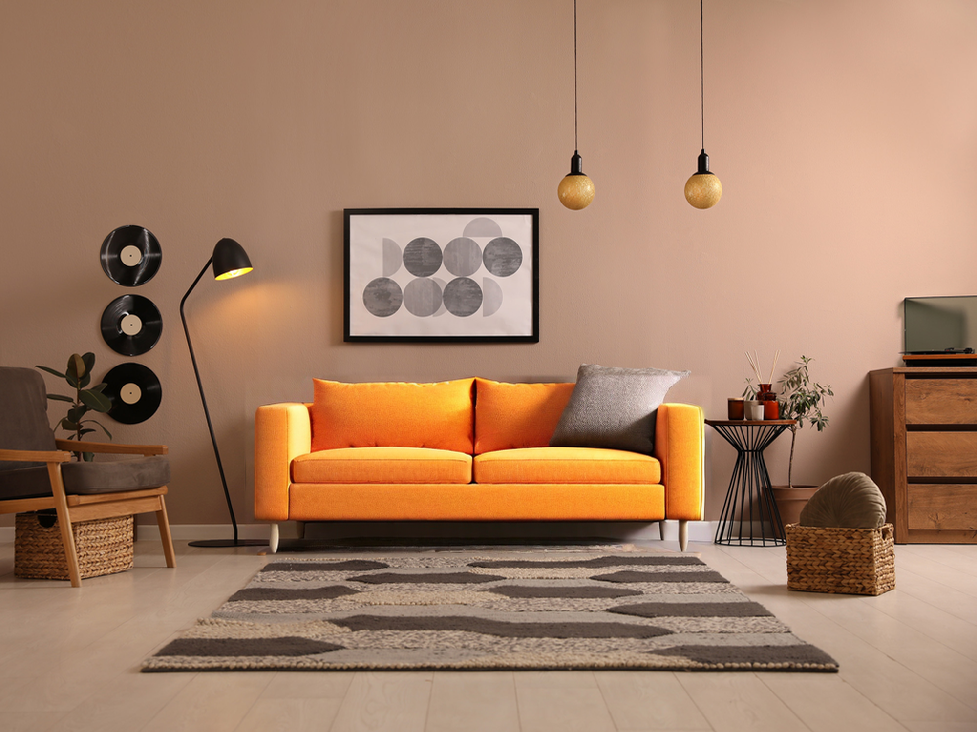 Un canapé orange dans une pièce entouré d'autres décorations.