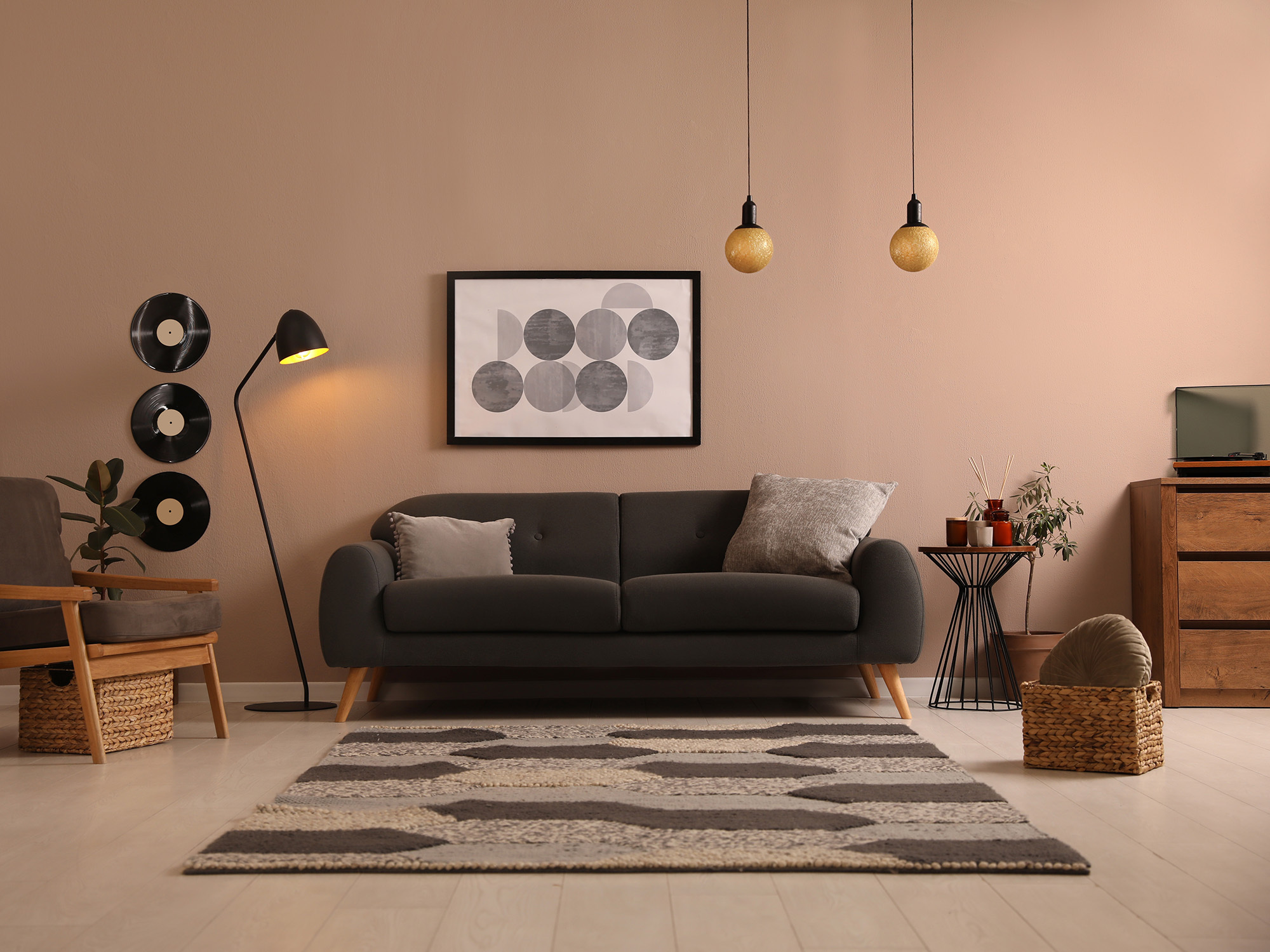 Un canapé gris moderne du milieu du siècle dans une pièce entouré d'autres décorations.