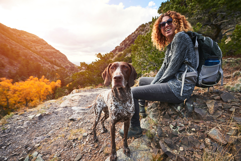 Femme faisant de la randonnée en plein air avec un chien.