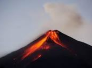 Vulcano in eruzione con lava fusa che scorre lungo i suoi fianchi contro un cielo nuvoloso.